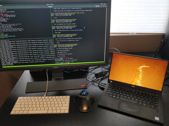 Photo of a Dell laptop with an Ubuntu background and a monitor, keyboard, and mouse